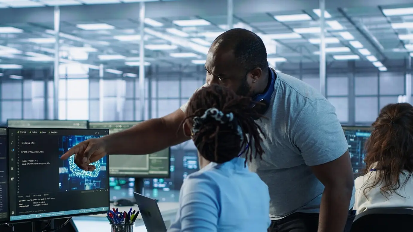 Руководитель наблюдает за работником, использующим программное обеспечение системы искусственного интеллекта.