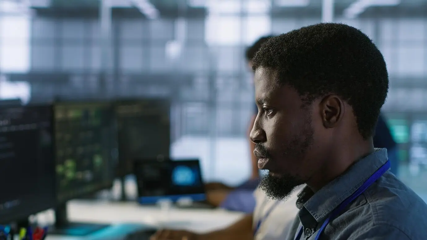 В центре внимания — мужчина в офисе серверного хаба, использующий искусственный интеллект.